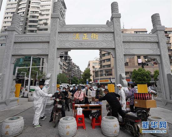  4月16日，進出武漢漢正街步行街的人員在掃描健康碼。新華社記者 王毓國 攝